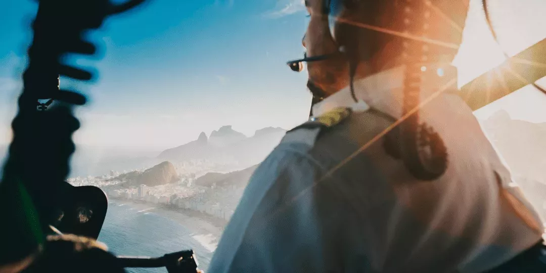 Pilote d’hélicoptère en vol au-dessus de la ville, symbole d’un leadership alliant prise de hauteur, alignement et maîtrise collective