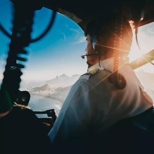 Pilote d’hélicoptère en vol au-dessus de la ville, symbole d’un leadership alliant prise de hauteur, alignement et maîtrise collective