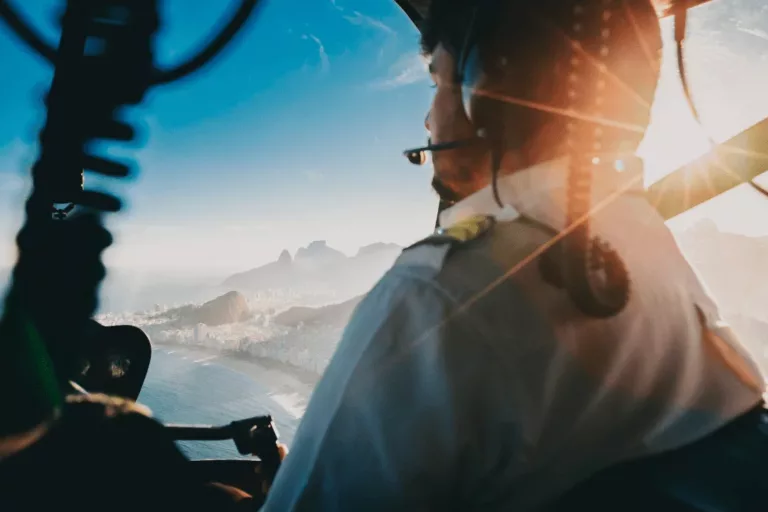 Pilote d’hélicoptère en vol au-dessus de la ville, symbole d’un leadership alliant prise de hauteur, alignement et maîtrise collective